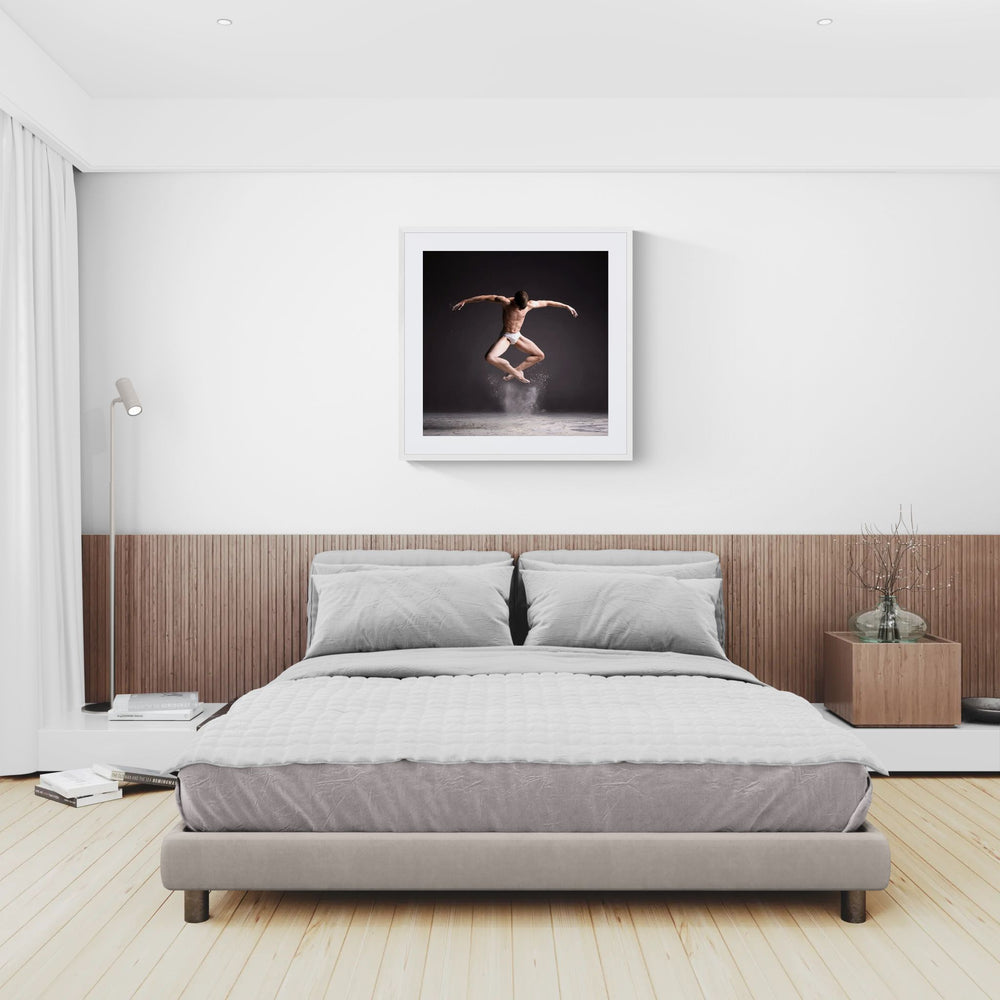 Framed Cloud Dancer – Powder Leap print above a grey bed in a bright neutral bedroom with white walls, wood headboard and light timber floor.
