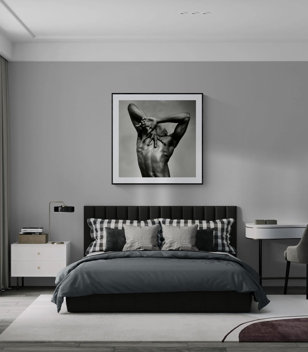 Framed J. by Sasha Onyshchenko fine art print displayed above a dark grey bed in a contemporary bedroom with minimalist interior design.