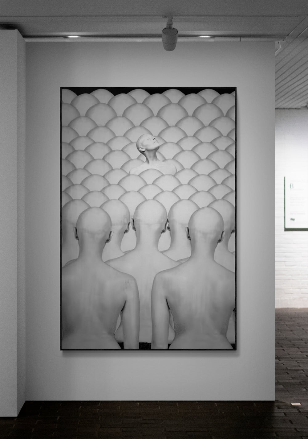 Artistic black and white photograph of bald heads in a patterned room.