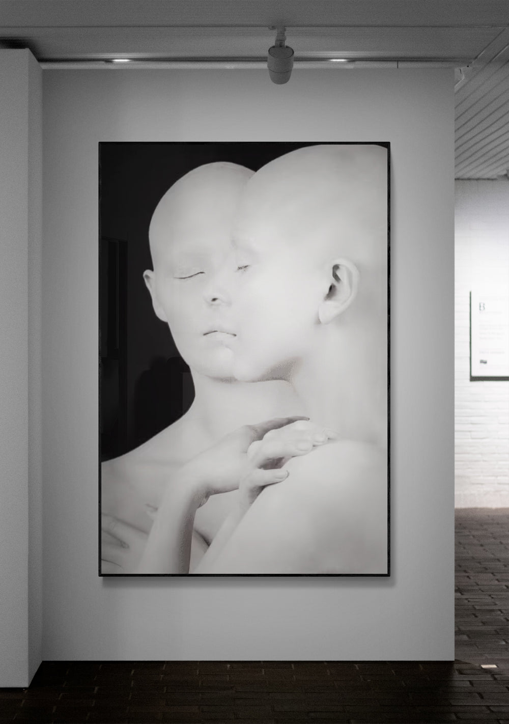 Black and white artwork of a stylized face on a wall in an art gallery.