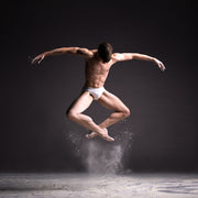 Cloud Dancer – Powder Leap by Francisco Estevez — a male dancer suspended mid-leap above a rising white powder cloud on a dark stage. Fine art dance photography, Dance Artworks Gallery.