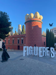 Exterior view of the Salvador Dalí Theatre-Museum in Figueres, Catalonia, showing the red façade crowned with golden eggs, symbolizing creation and artistic rebirth.
