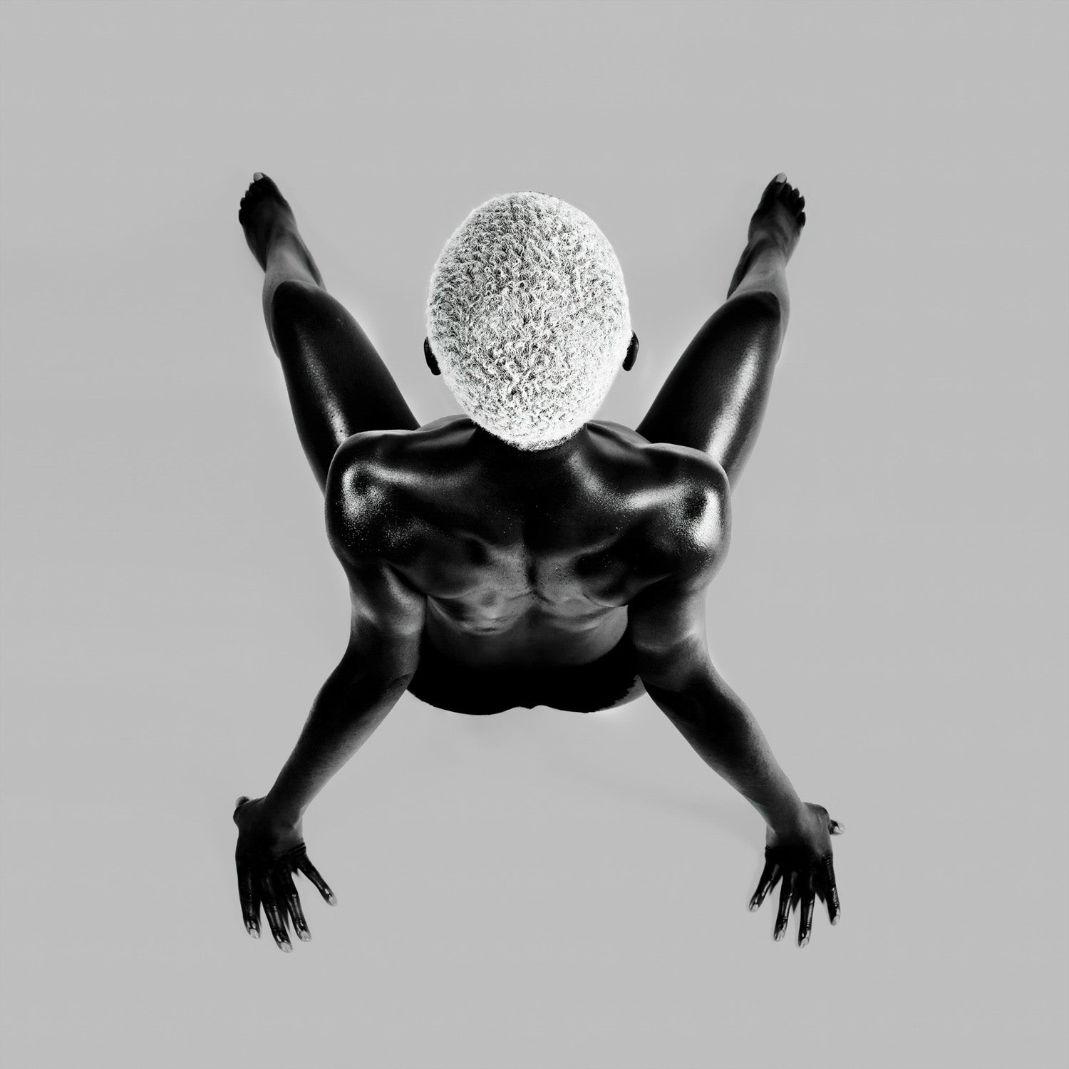 Overhead composition marking a drop of weight; rhythm settles as gravity sets the measure.