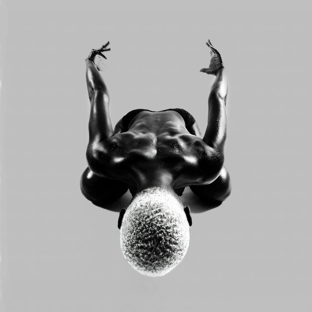 Symmetric overhead pose with arms lifted; axis held and balance secured in a calm, measured frame.