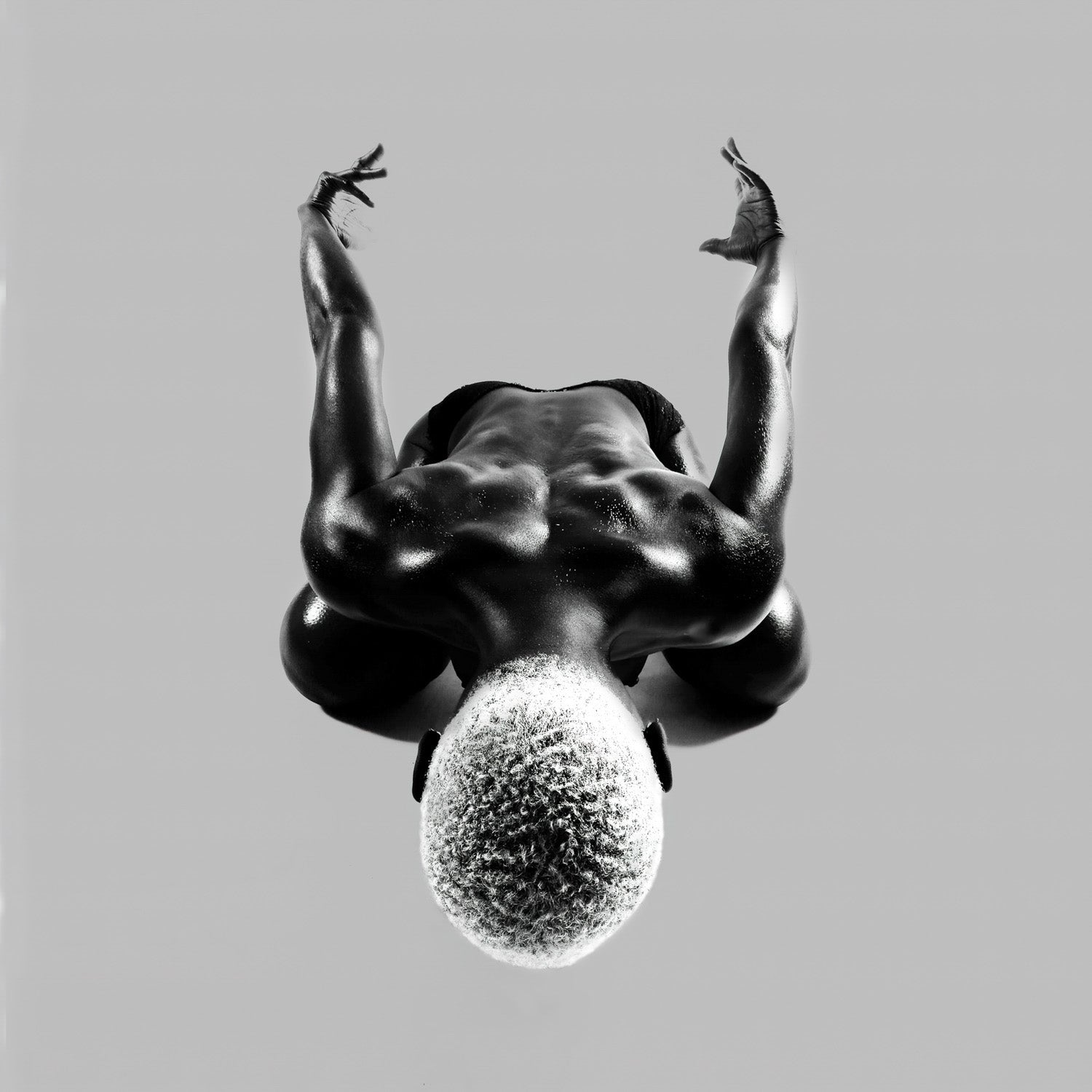 Symmetric overhead pose with arms lifted; axis held and balance secured in a calm, measured frame.