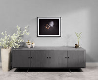 Framed Cloud Dancer dance photograph on a light grey wall above a ribbed grey sideboard, with a tall vase of white blossoms and minimalist ceramics.
