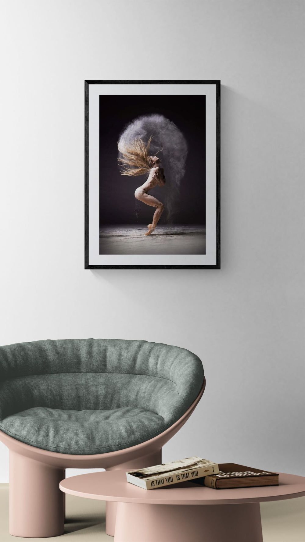 Framed Cloud Halo dance photograph hanging above a rounded green chair and pink low table in a minimalist living room.