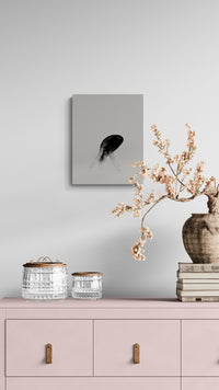Decorative setup with a pink cabinet, vases, and a fine art print on a light gray wall.