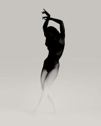 Arms curve overhead as the figure lightens; balance, pause, and a dissolving arc in white.