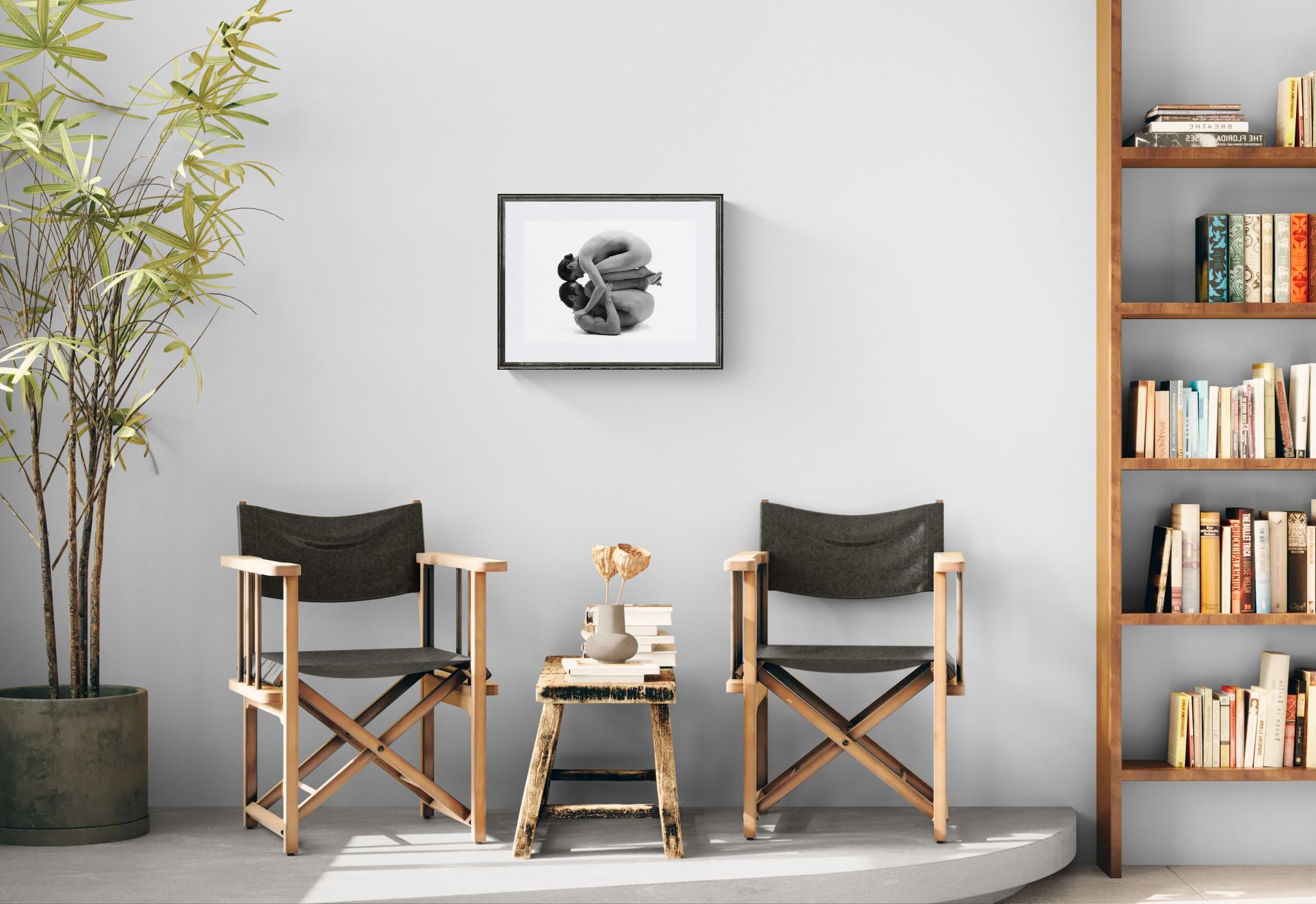 Two director's chairs with a small table in a room with a bookshelf and plant.