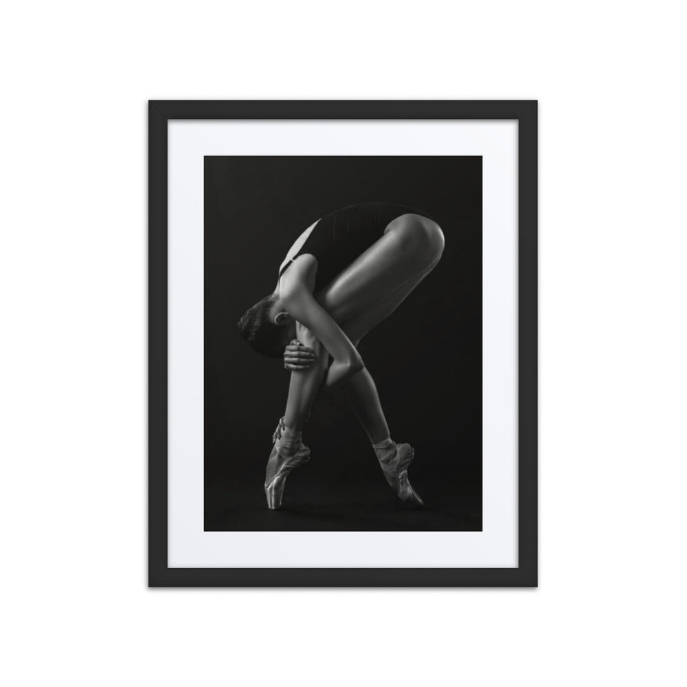 An artistic black-and-white photograph of a ballerina on pointe, gracefully arching her body into a mesmerizing pose.