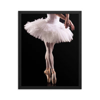 Framed fine art poster titled 'Ballerina En-Pointe,' showcasing the lower body of a poised ballerina on pointe wearing a delicate white tutu. Captured against a dramatic black backdrop, this artwork embodies elegance and timeless grace.