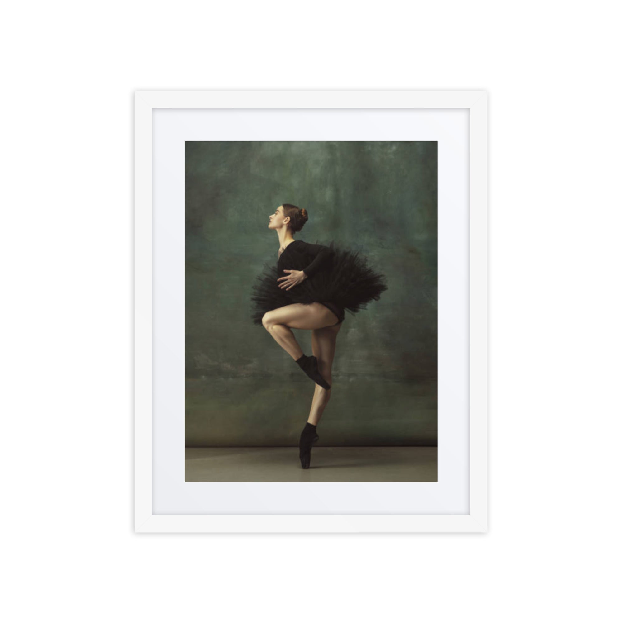 A poised ballerina wearing a black tutu captured mid-pose, embodying grace and precision against a soft green background.