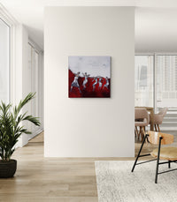 Abstract painting on a wall in a modern interior setting with a plant and furniture.