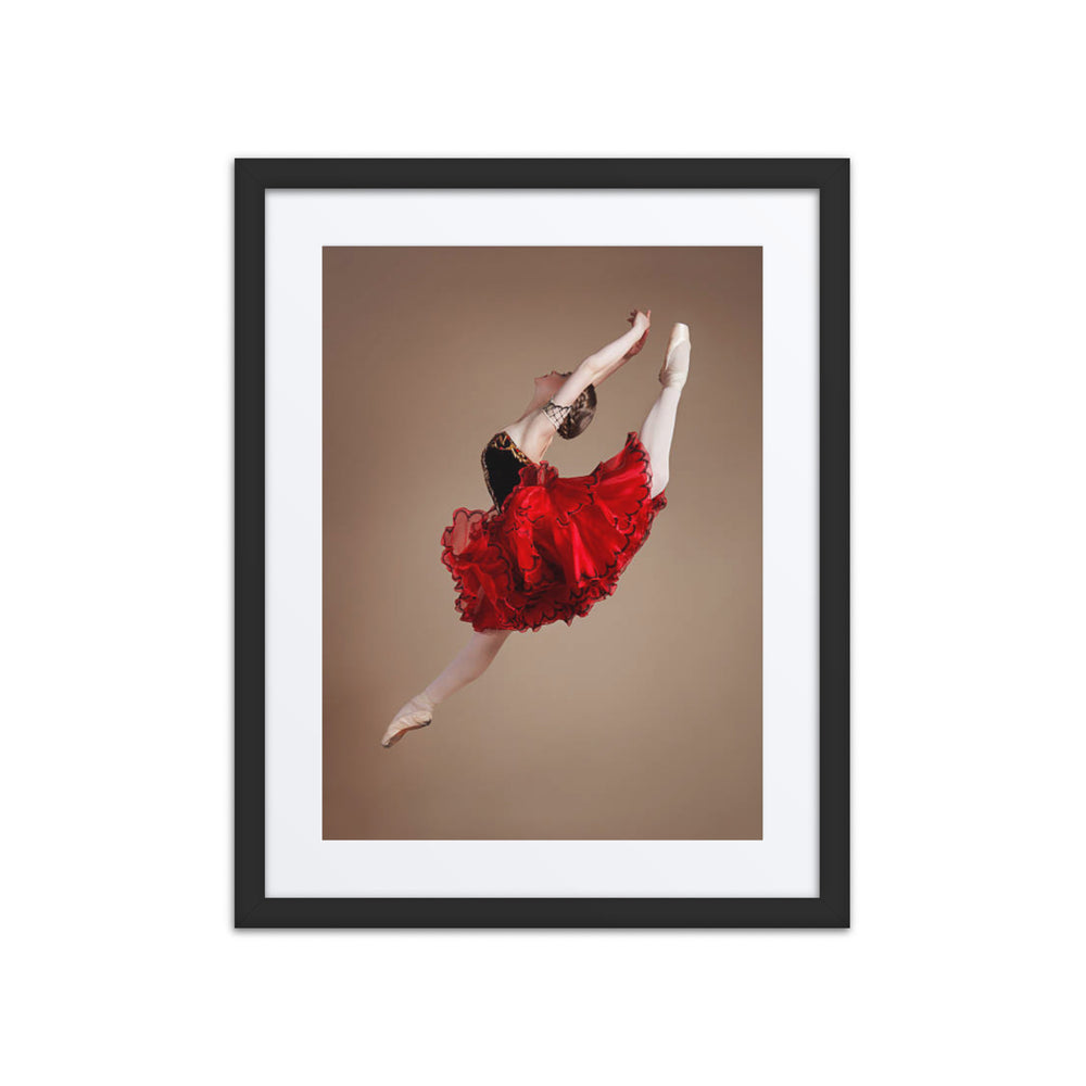 A captivating photograph of a ballerina mid-leap, dressed in a vibrant red tutu with black accents. The dynamic motion and vivid colors highlight the energy and passion of classical ballet.