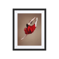 A captivating photograph of a ballerina mid-leap, dressed in a vibrant red tutu with black accents. The dynamic motion and vivid colors highlight the energy and passion of classical ballet.