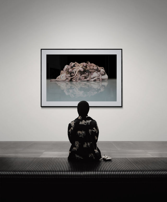 Dance photography print centered to a seated viewer, anchoring the focal plane in a modern gallery interior.