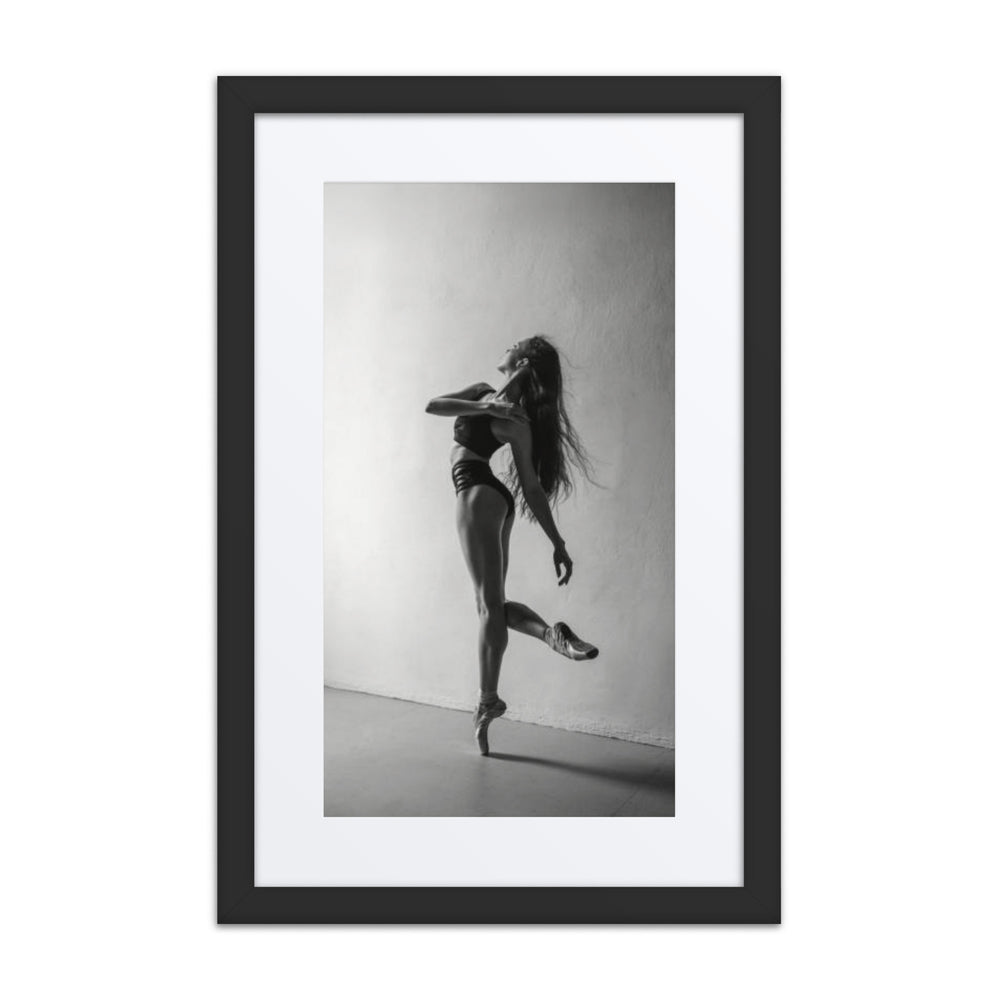 A black-and-white portrait of a dancer mid-pose, her hair flowing as she balances on pointe, capturing movement and elegance.