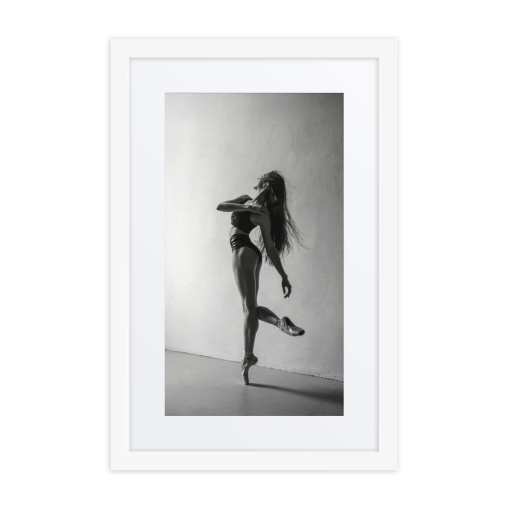 A black-and-white portrait of a dancer mid-pose, her hair flowing as she balances on pointe, capturing movement and elegance.