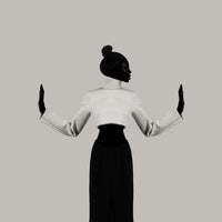 Silhouette of a person wearing a white blouse and black skirt against a plain background
