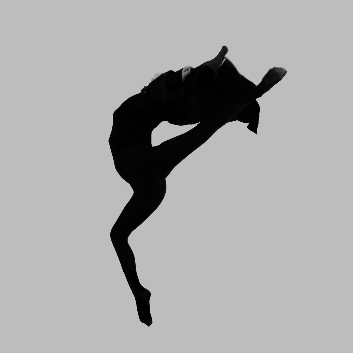 FLY by FX Pelissier, black-and-white photograph of a dancer suspended mid-air against a grey background.