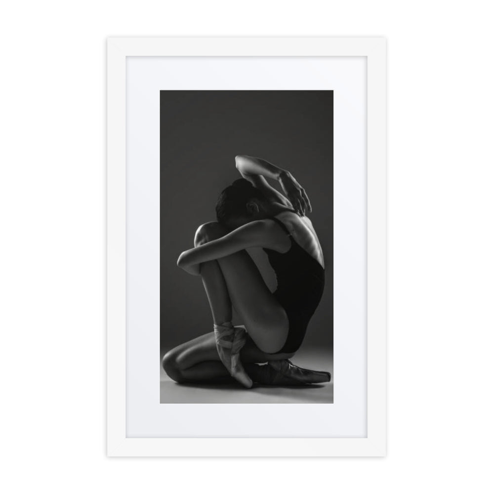 A captivating black-and-white portrait of a seated ballerina in a thoughtful pose, emphasizing grace and introspection.