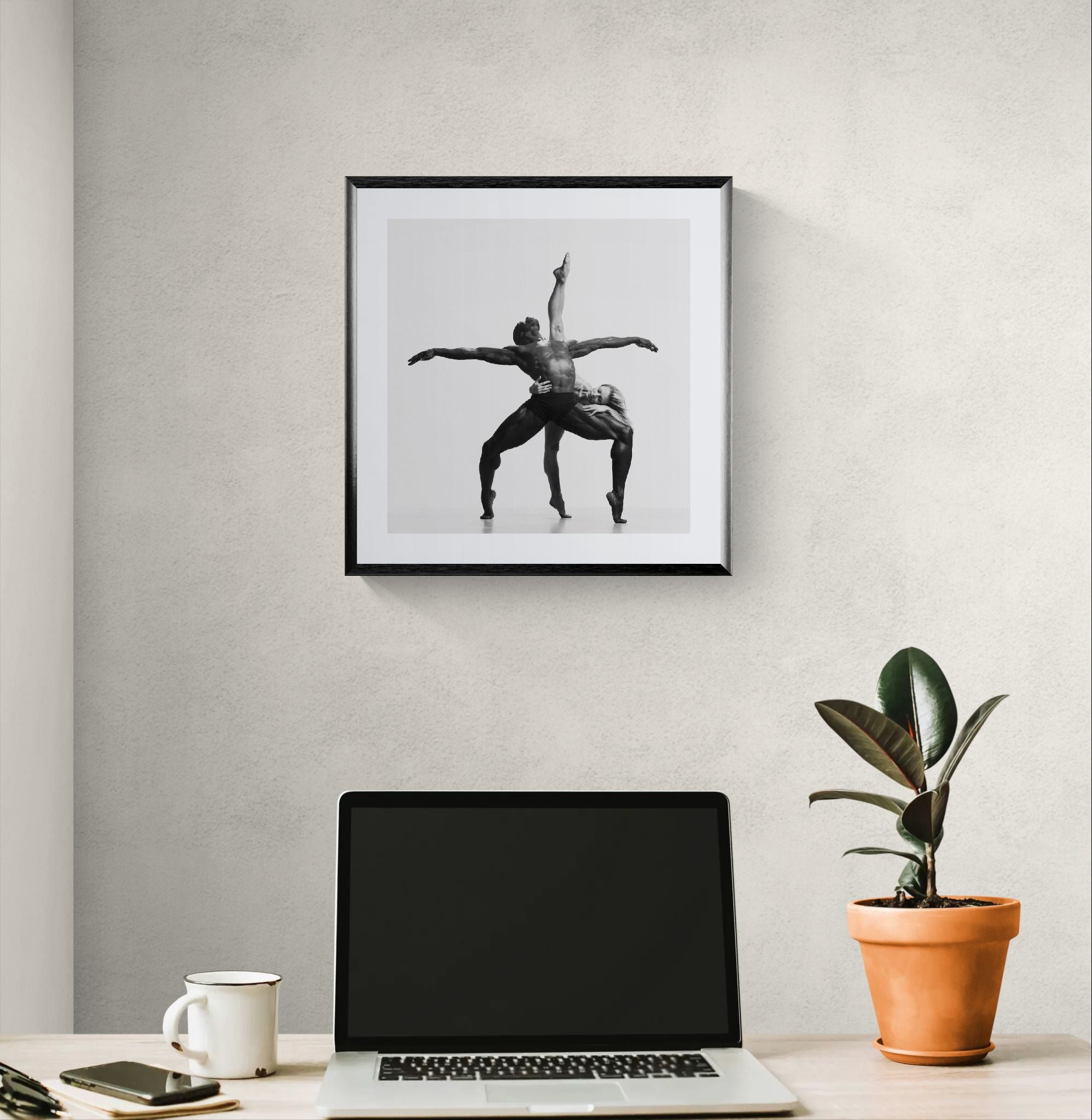 Soft neutral bedroom with low bed and wood headboard, a framed square black-and-white dance photograph hanging above.
