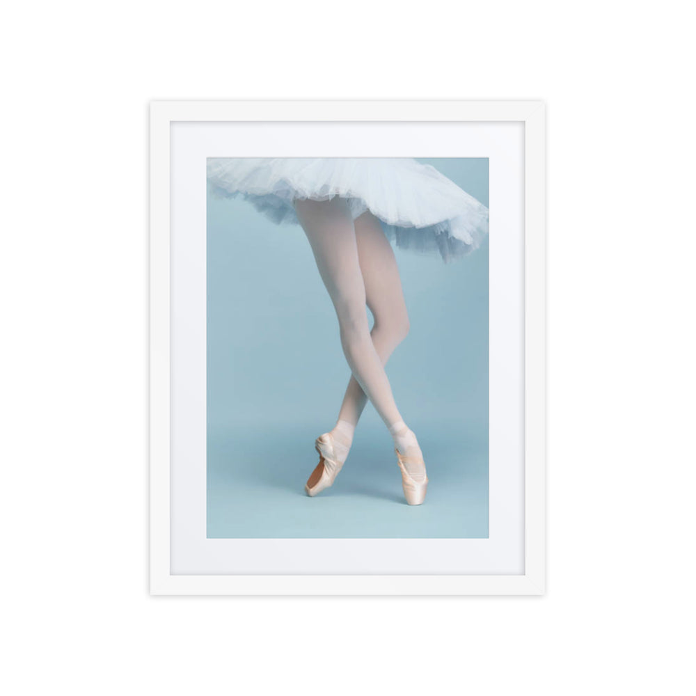 A ballerina on pointe, her legs poised in a classical pose, with soft, flowing tulle creating a delicate contrast against a pastel blue background. The image captures the elegance and precision of ballet, evoking a timeless sense of grace and beauty.