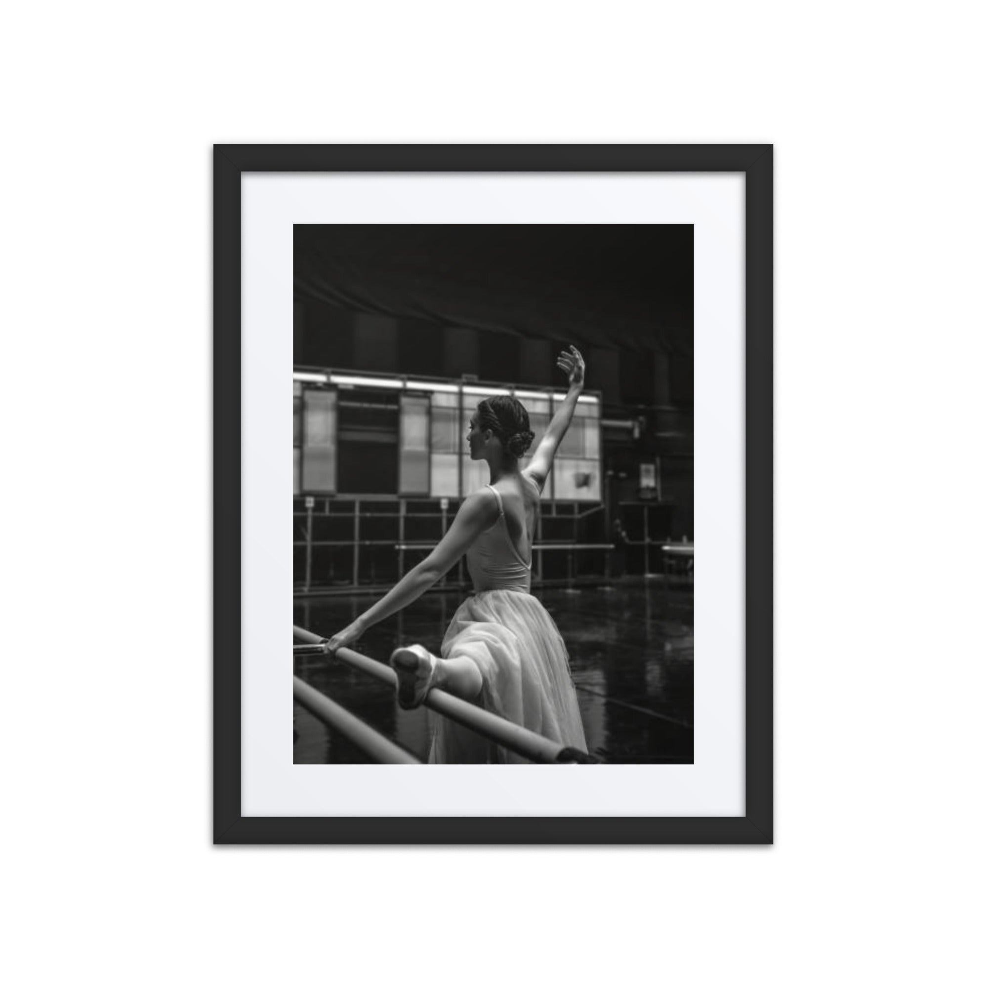 A captivating black-and-white image of a ballerina practicing in a dimly lit studio, evoking timeless beauty.