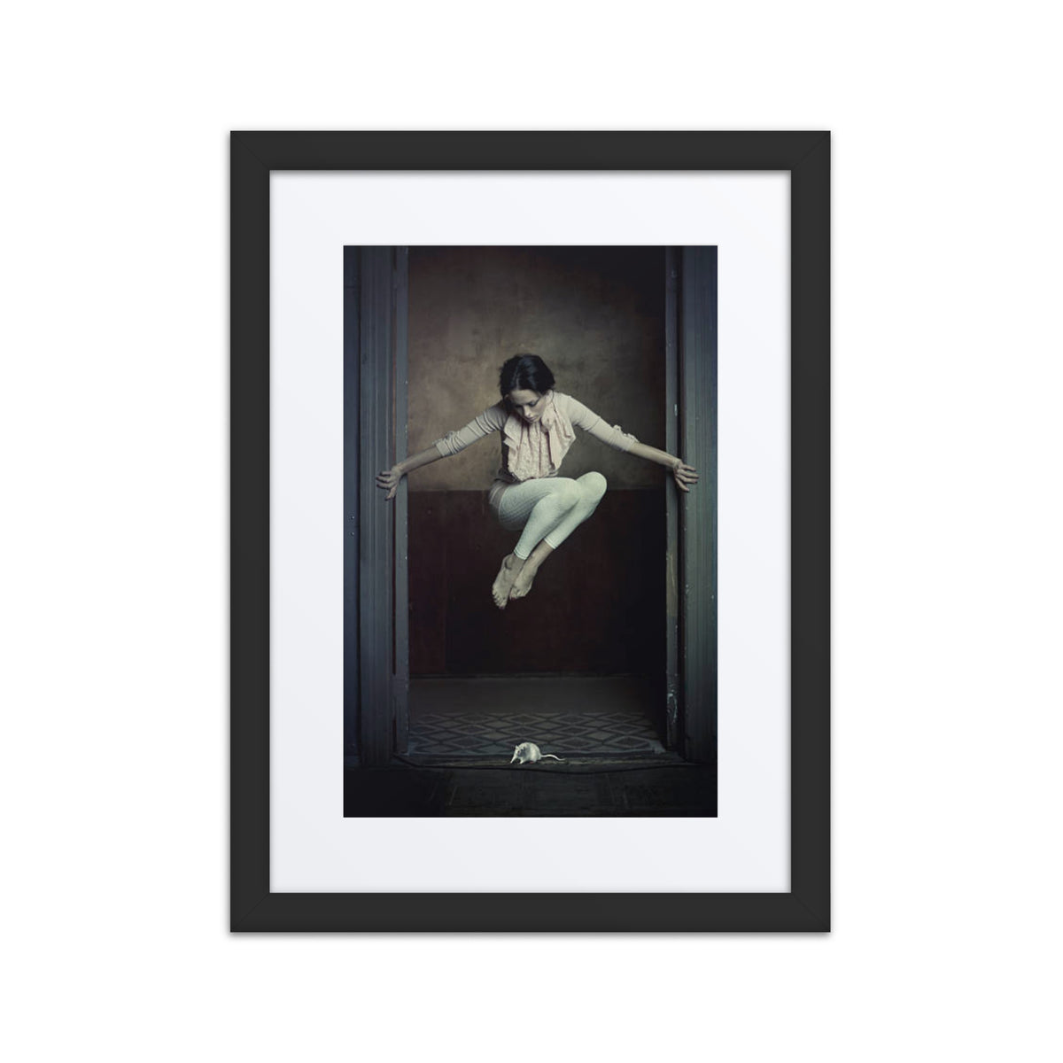 A whimsical photograph of a ballerina leaping gracefully in response to a mouse on the floor, framed in an elegant rustic doorway.