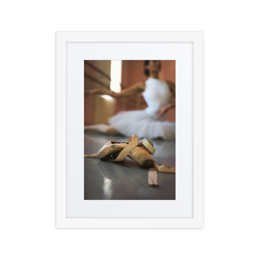 A heartfelt composition featuring a close-up of well-worn pointe shoes on a dance studio floor, with a blurred ballerina in a tutu gracefully stretching in the background, capturing the dedication and artistry of ballet.