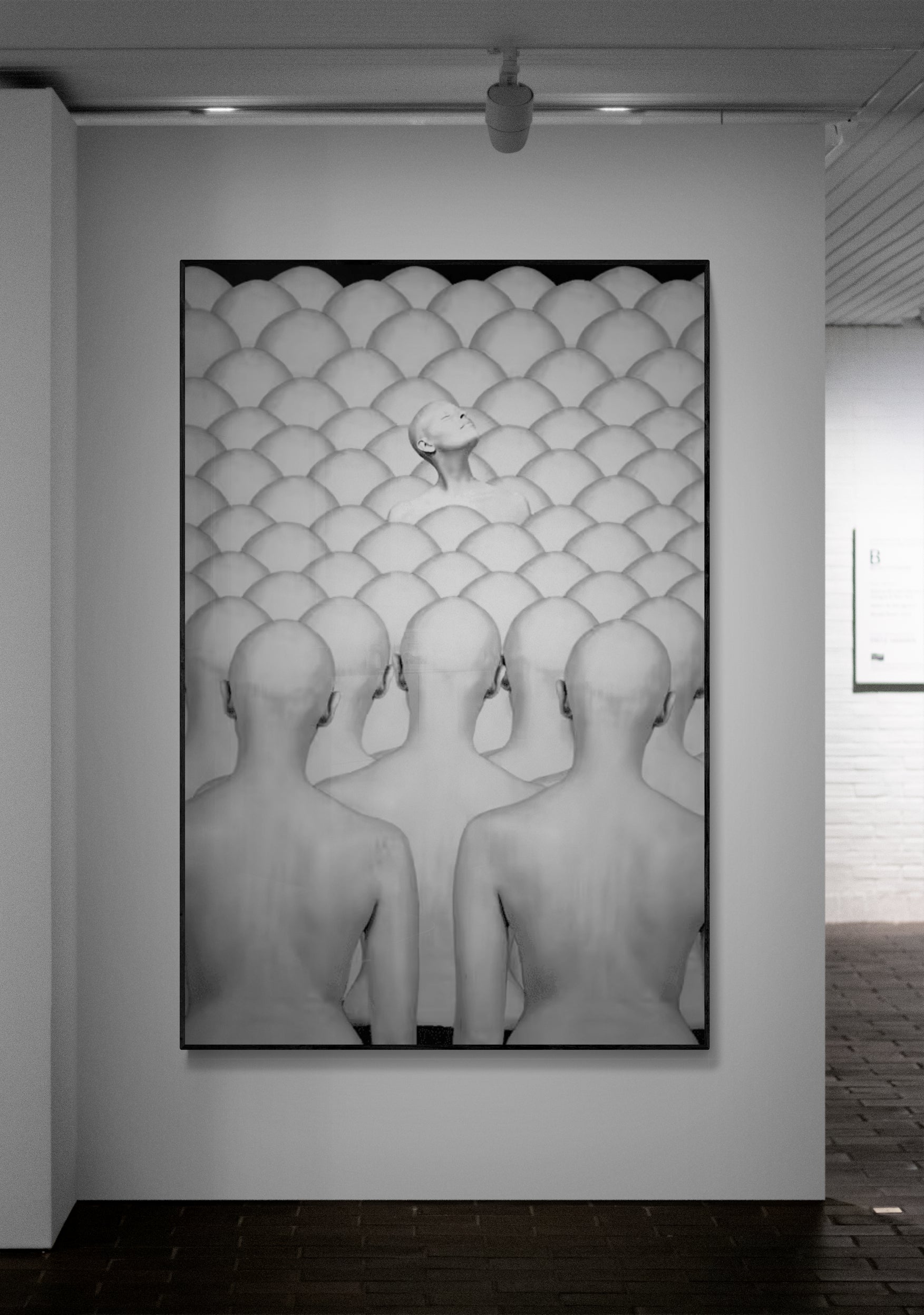 Artistic black and white photograph of bald heads in a patterned room.