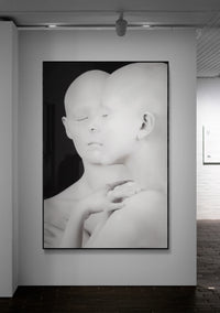 Black and white artwork of a stylized face on a wall in an art gallery.