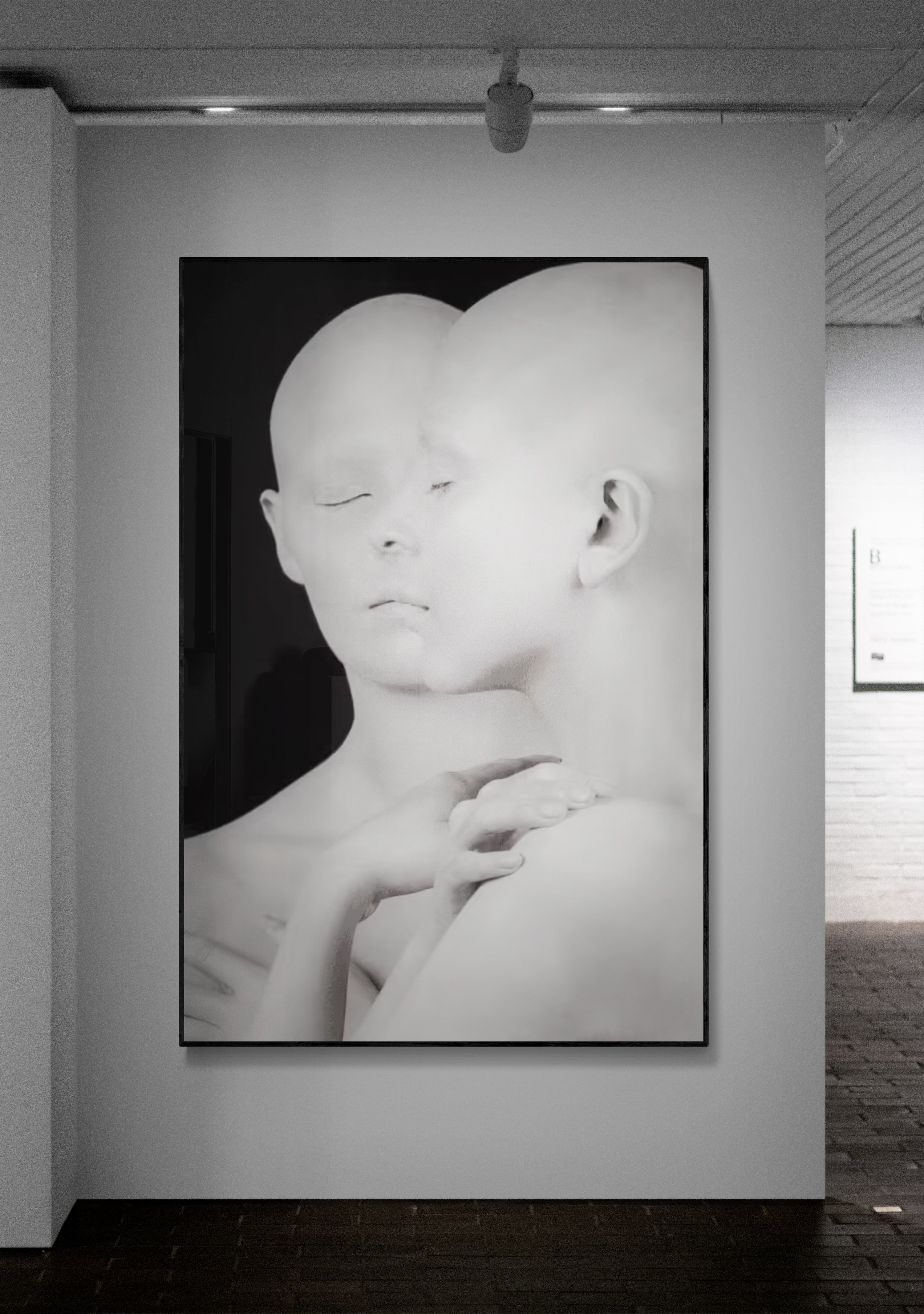 Black and white artwork of a stylized face on a wall in an art gallery.
