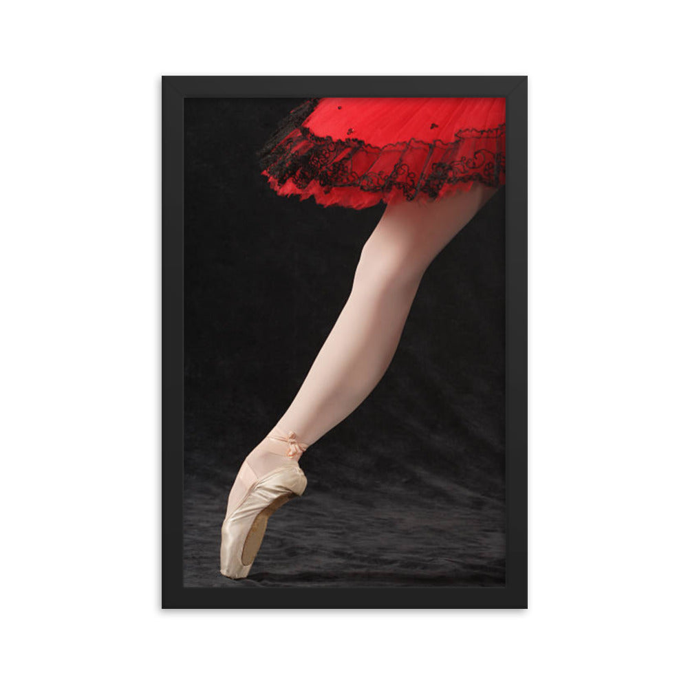 A refined close-up of a ballerina’s pointe shoe under a red lace-trimmed tutu, showcasing the detail and discipline of classical ballet.