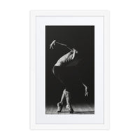 A powerful black-and-white photograph of a male dancer mid-performance, capturing his poised elegance and the interplay of shadow and light on the stage floor.