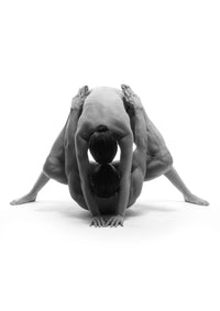 Black-and-white fine art nude dance photograph of two dancers in a partnered, folded pose on a white background.