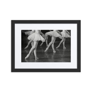 A captivating black-and-white photograph capturing ballerinas in elegant tutus, performing in perfect synchronization on stage.