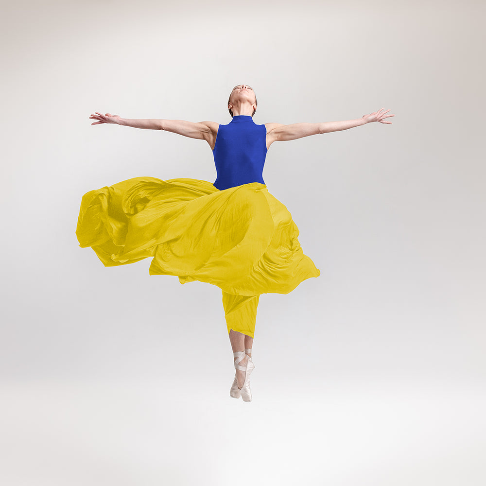 Ballerina photographed in a position with her wide open arms like a cross. She is wearing a costume in blue and yellow like the Ukraine flag. All the profits from this print will go to help the refugees in Ukraine