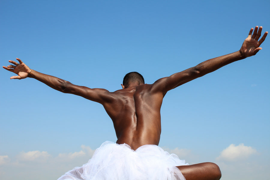 With open arms, we see a black male spreading his hands like wings into the blue sky. 