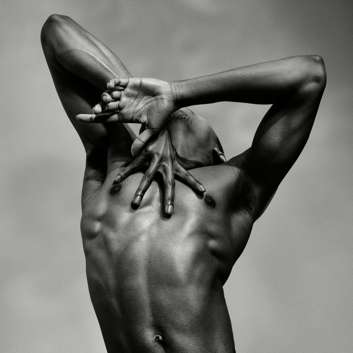 Close-up photograph of a male dancer and hands from the artwork J. by Sasha Onyshchenko, showing sculptural musculature and expressive hand placement in monochrome fine art style.