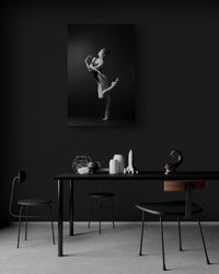 Artwork on a black painted wall, dining room. Ballerina, bodysuit, graceful dancing, black and white photography print.